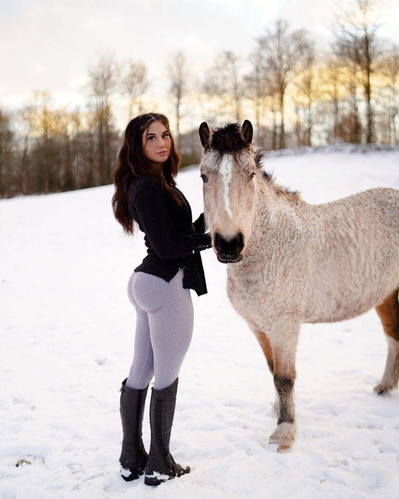 Amanda Fransson is standing in snow with white animal and posing for the picture