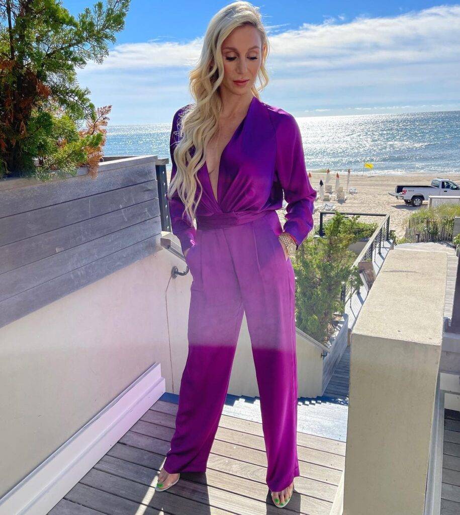 Charlotte Flair is wearing purple dress and posing for the picture