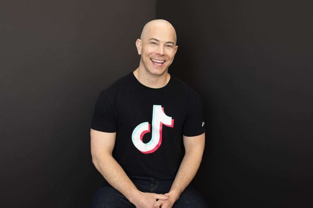 Dr. Dustin Portela is just posing for a picture while wearing a TikTok shirt as he is a TikTok star.