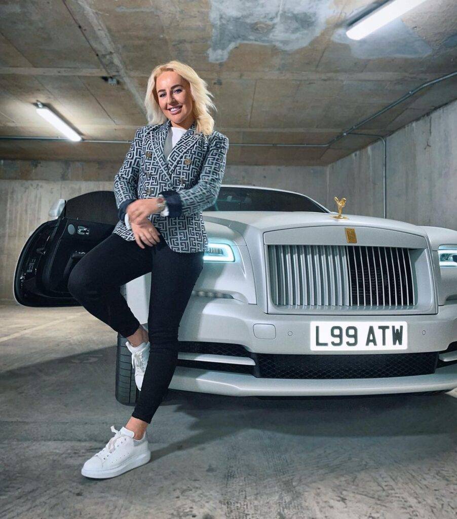 Liv Cooke is looking hot and sweet in the pant coat and standing in front of Rolls Royce car and taking picture