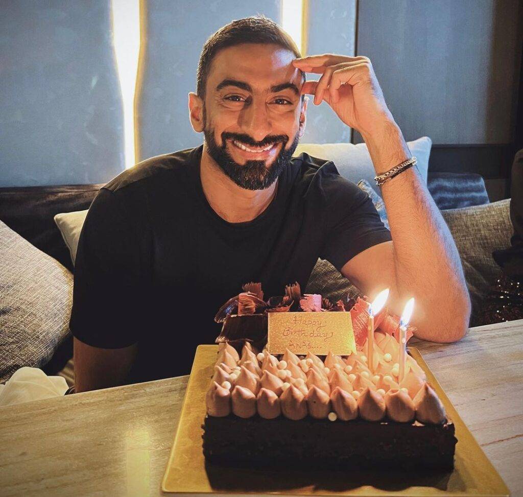 Anas Bukhash in the black t-shirt pair with black pant while taking picture with his birthday cake