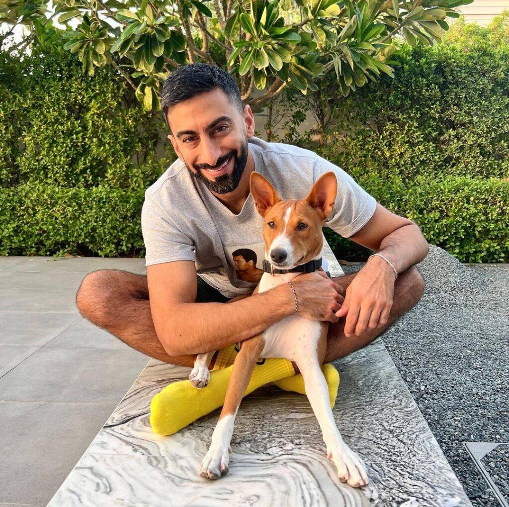 Anas Bukhash in the grey t-shirt pair with matching shorts while poses for a photo with his dog