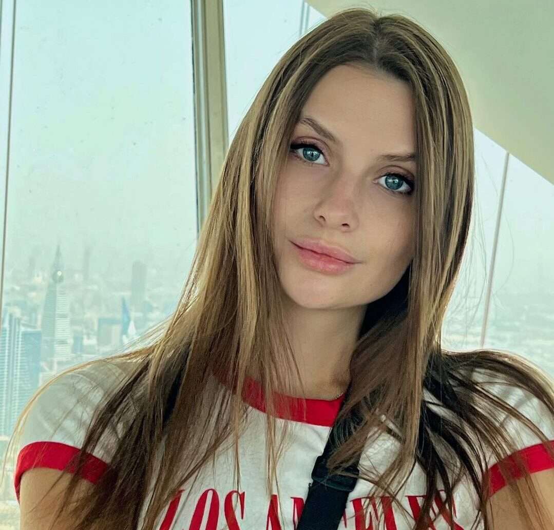 Svetlana in the white and red contrast t-shirt while taking a selfie and looking towards camera