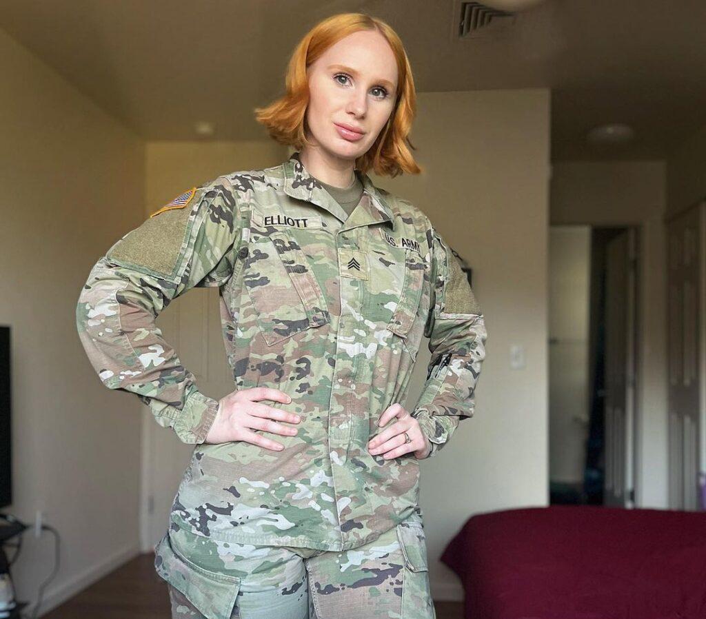 Ashley Elliott in the army costume while taking a picture in her bedroom and looking towards camera
