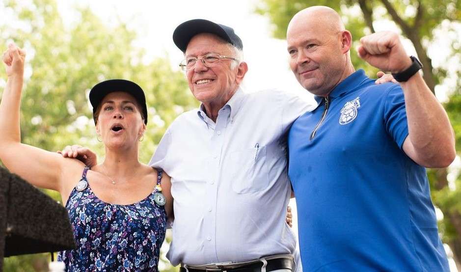 Bernie Sanders is with his people while sloaganing there and is smiling.