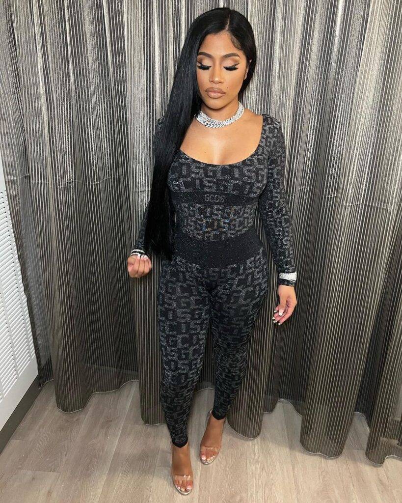 Hennessy Carolina in the printed black jumpsuit pair with white bangles and poses for a photo