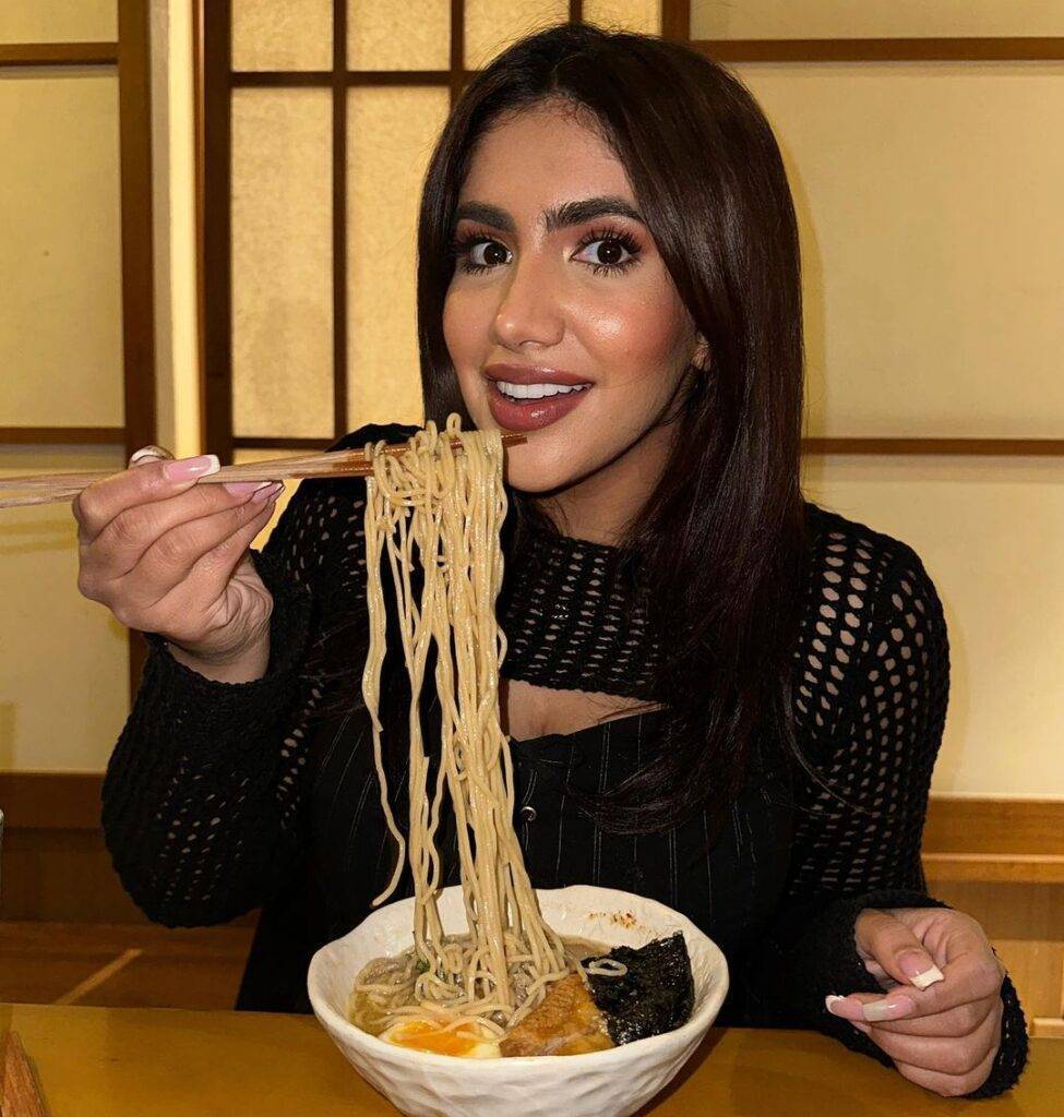Noor Stars in the black sexy outfit while eating noodles and smiling towards camera