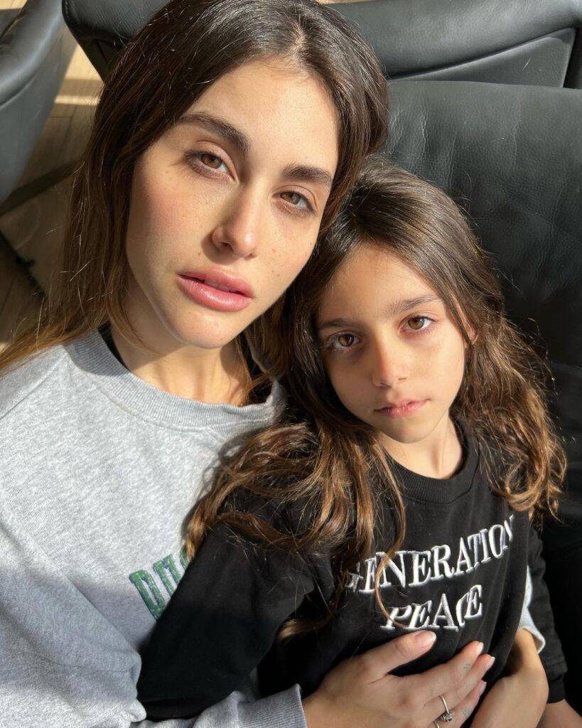 Nour Arida in the grey t-shirt while taking a sun kissed picture with her daughter