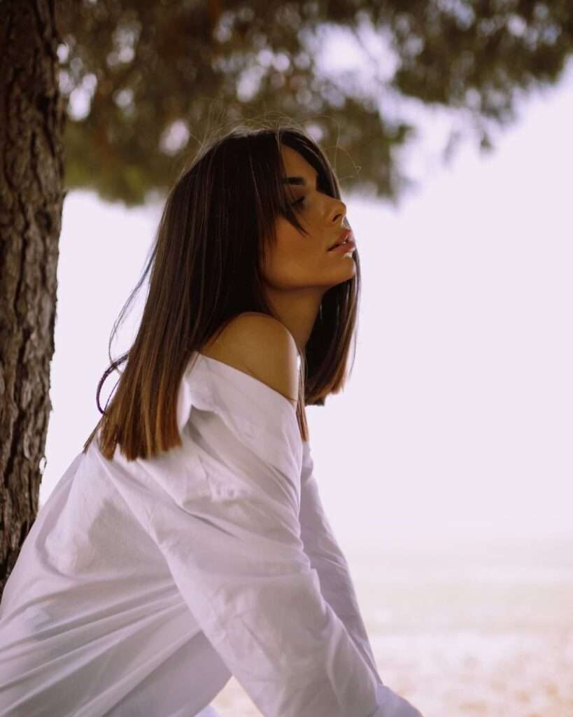 Rocio gonzalez in the white dress shirt while showing her jawline towards camera