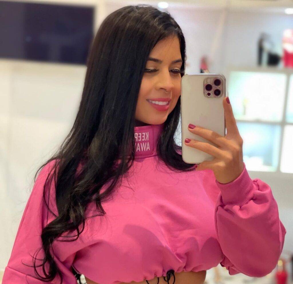 Suellen Lara in the pink crop top pair with matching trouser while taking a picture in the front of mirror