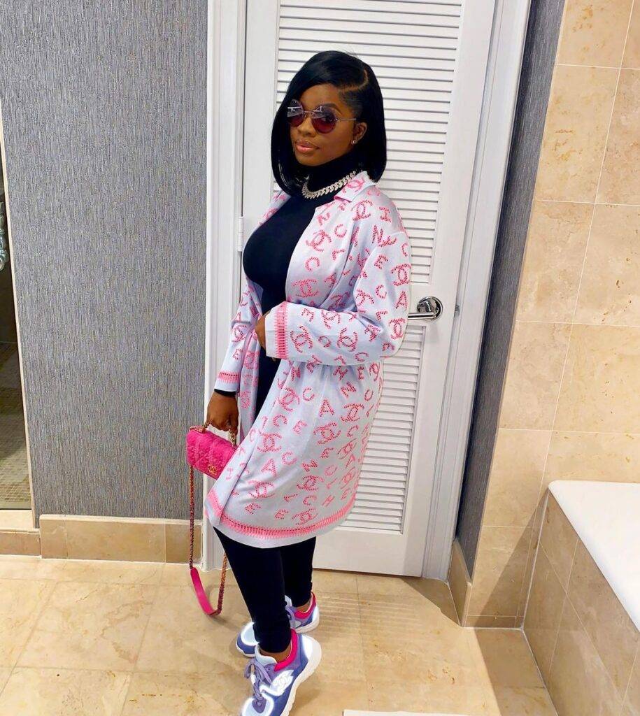 Jatavia Shakara Johnson  in the blackout pair with joggers, pink handbag, goggles, and white printed shrug