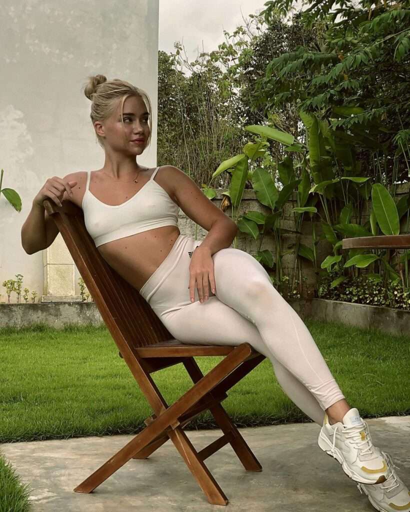 Alice Swifty is wearing white bra and trouser or sitting on the chair while posing for the picture