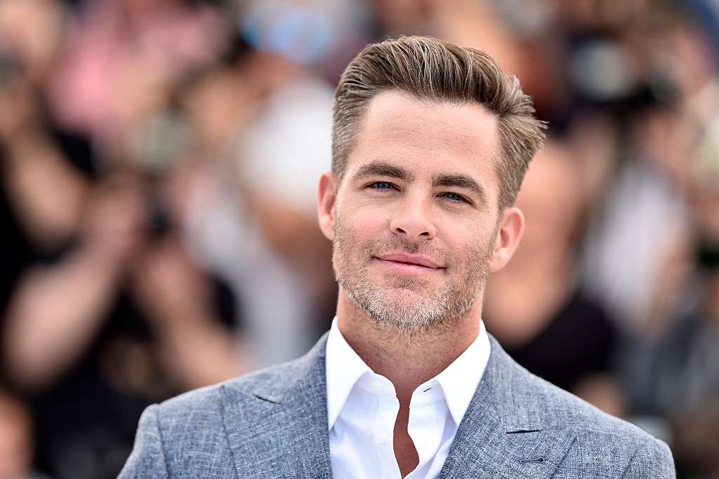 Chris Pine is looking handsome in the three piece suit while looking towards camera
