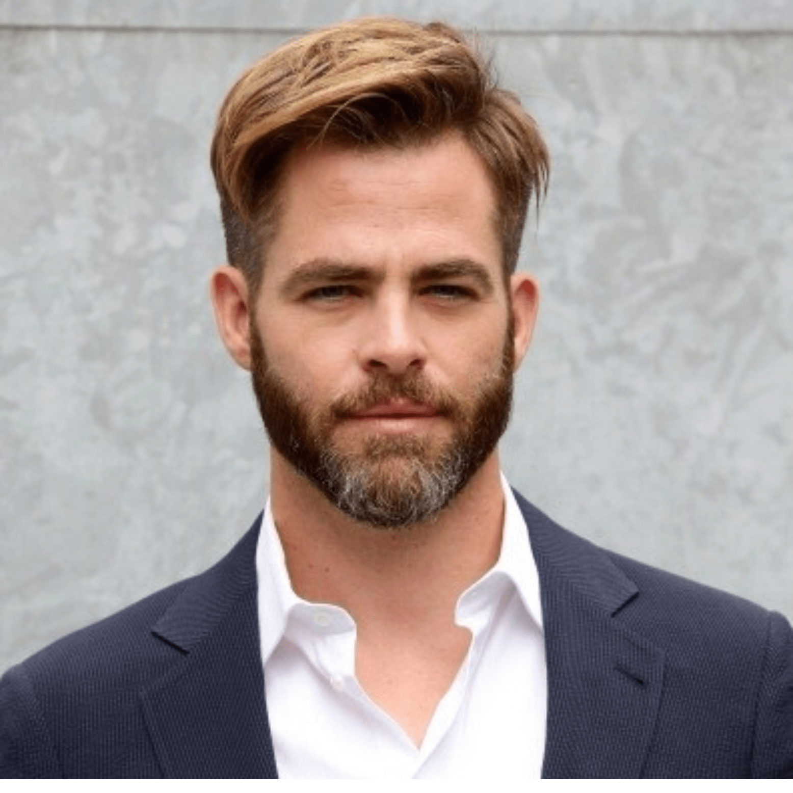 Chris Pine in the white dress shirt pair with blue coat while looking towards camera