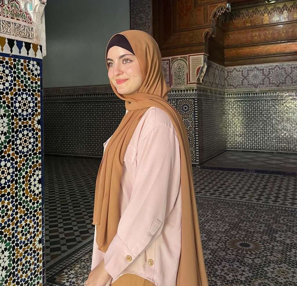 Amina Dehbi in the pink top pair with brown trouser and stole while taking photo in a mosque