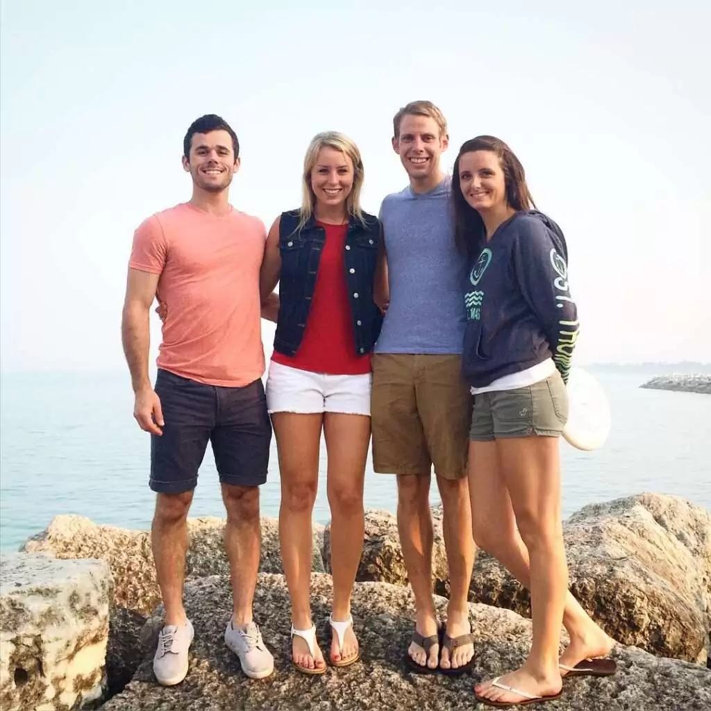 Daniel Labelle is posing for a picture with their friends while standing on the sea and is looking so happy