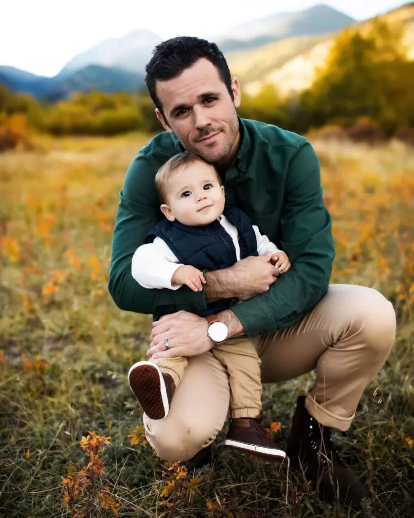 Daniel Labelle is posing for a picture with his baby boy and is looking happy
