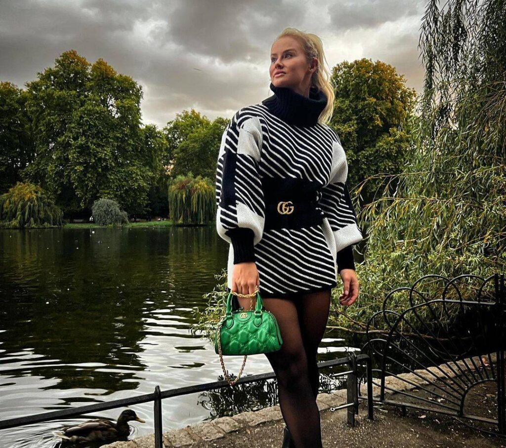 Dani Elle Speegle in the white and black high neck top pair with pantyhose and black shoes and green bag