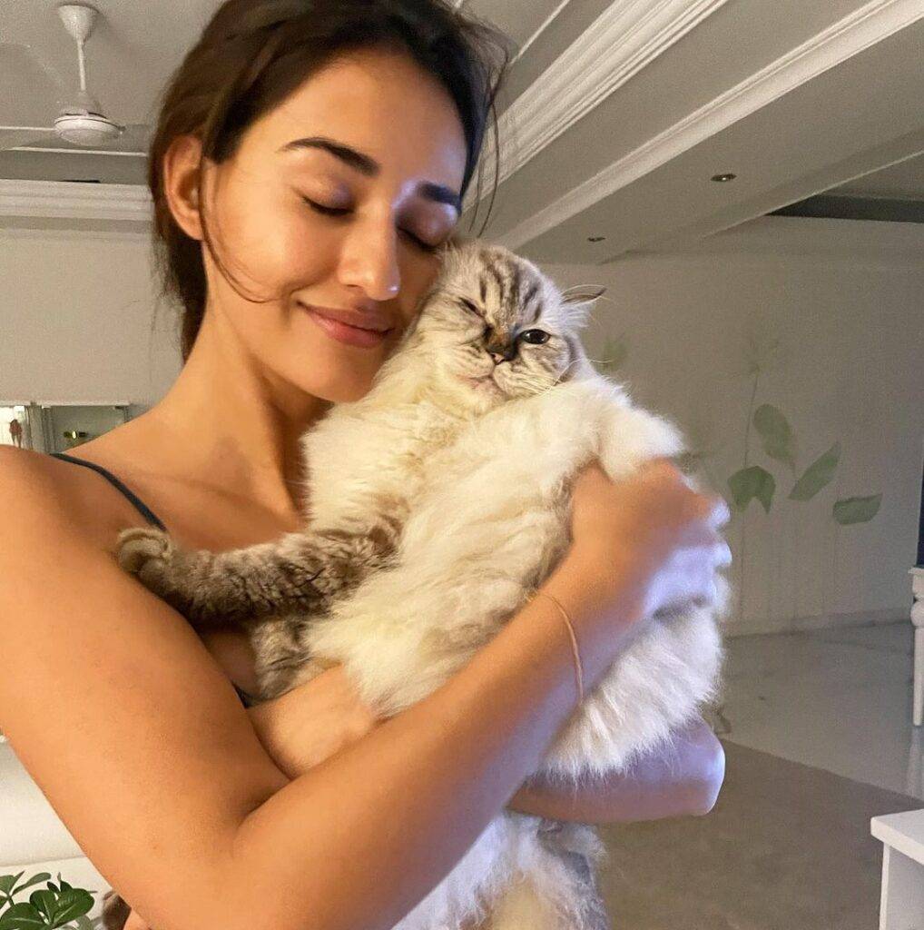 Disha Patani in the bralette while holding her cat and poses for a photo in her home