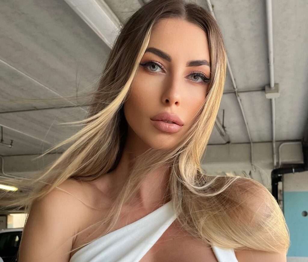 Eva Menta in the white sexy top while looking toward camera for a picture