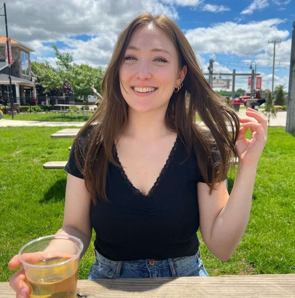 Julia-Tv in the short sleeves black top pair with blue jeans while taking her favourite drink