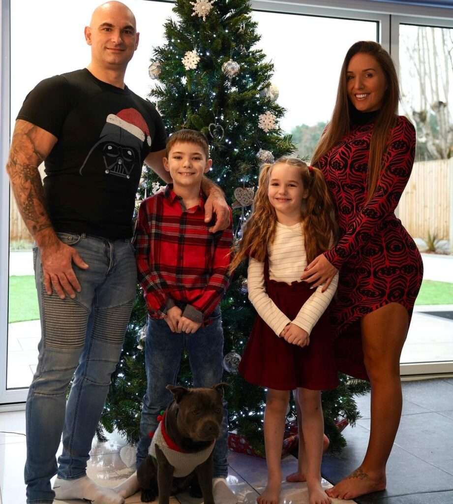 Kim French in the sexy red and black outfit while taking a group photo with her family in the front of Christmas tree
