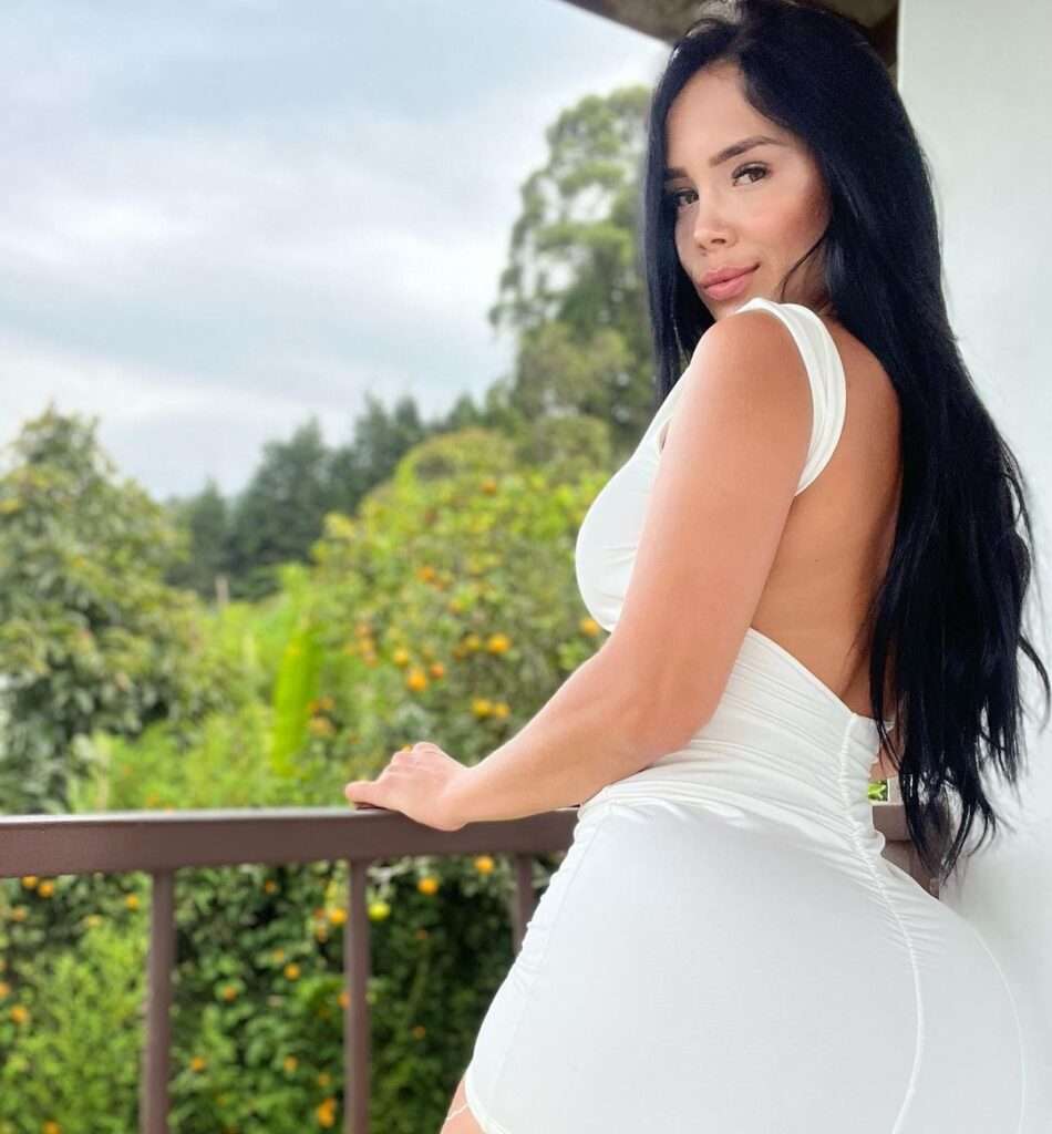 Elizabeth lopez in the white sexy bodycon while poses for a photo and smiling towards camera