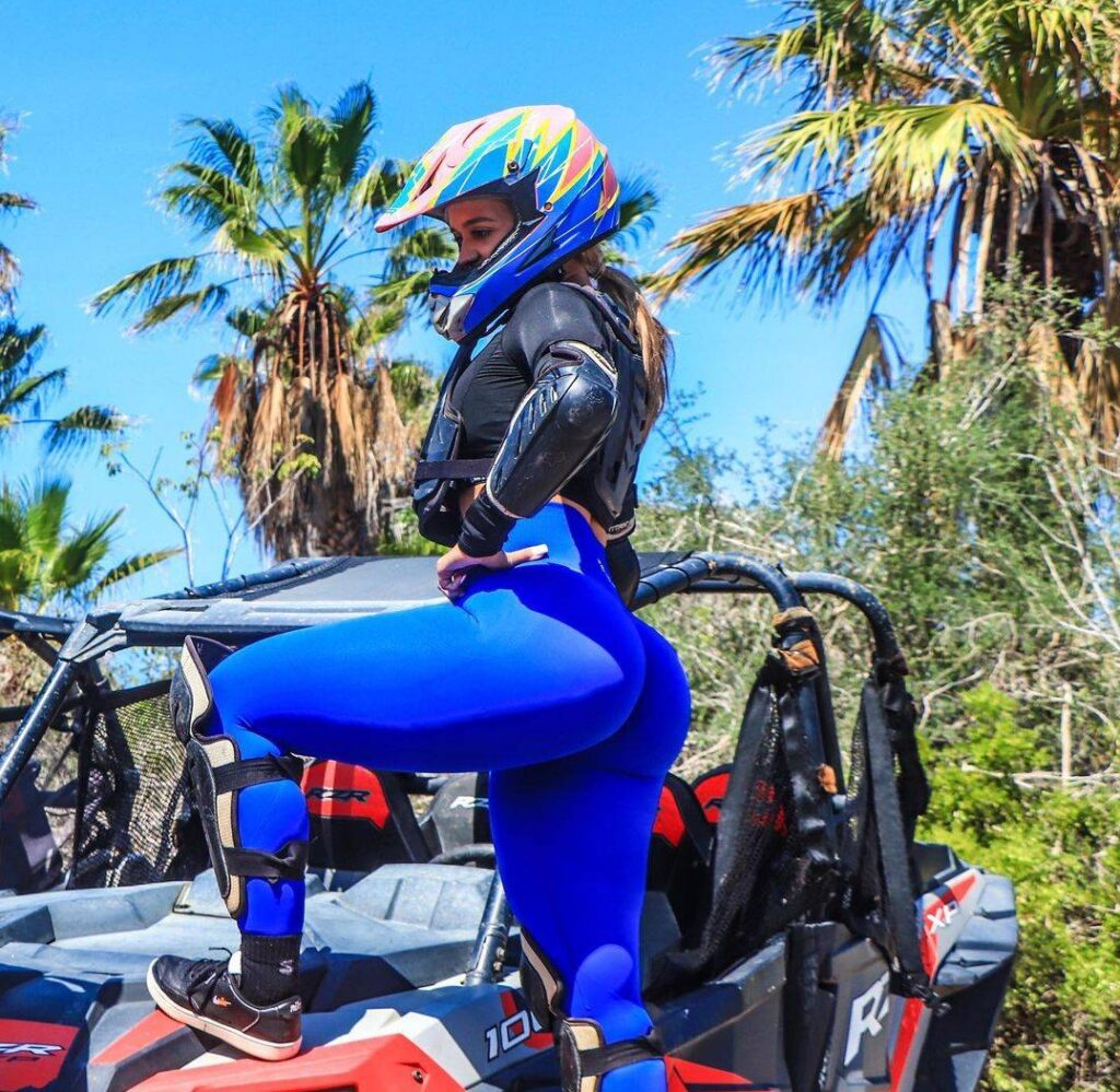 Nadia G in the Sexy Blue outfit with helmet while standing on the jeep and poses for a picture