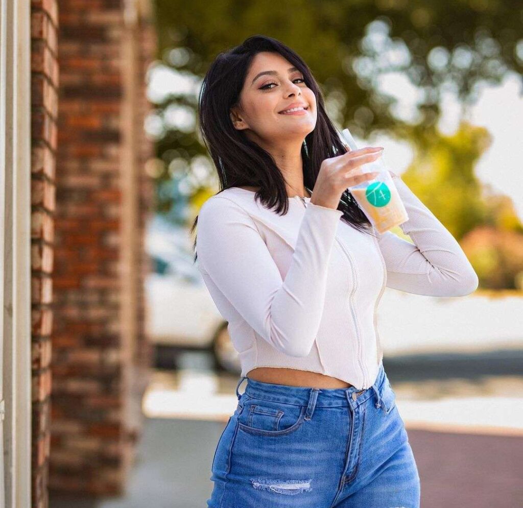 Toor Manpreet in the whilte sexy top pair with blue jeans while holding fresh juice on her hands