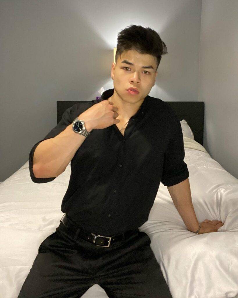 William Li in the black dress shirt pair with black pant while poses for a picture
