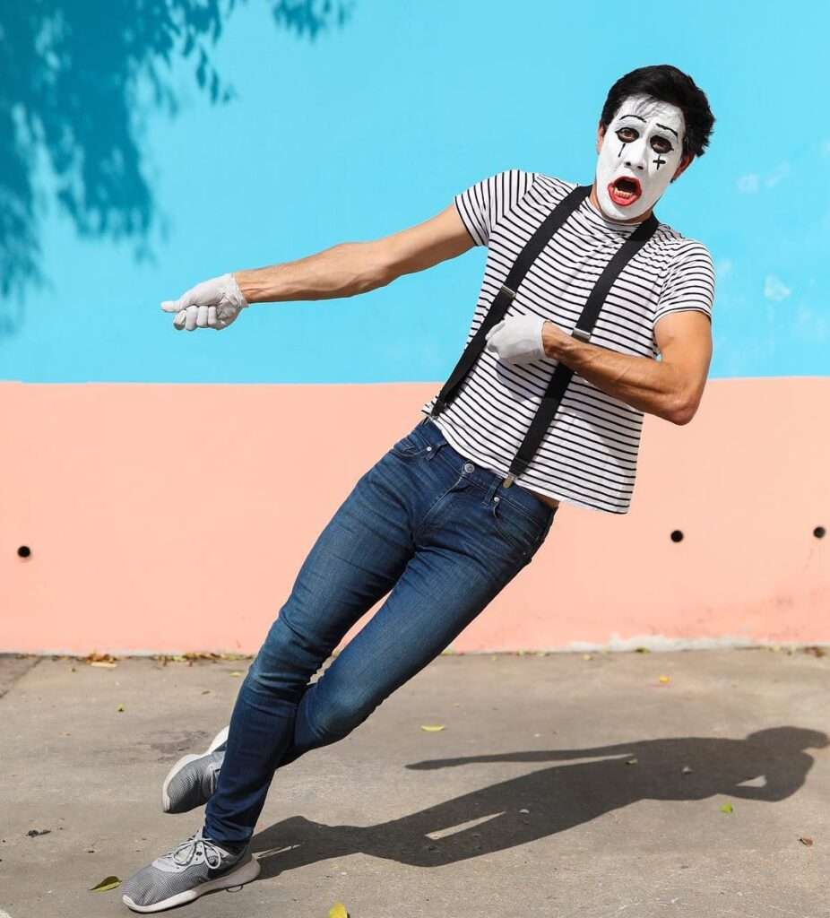 Zach king in the t-shirt pair with blue jeans and grey joggers while taking a funky photo