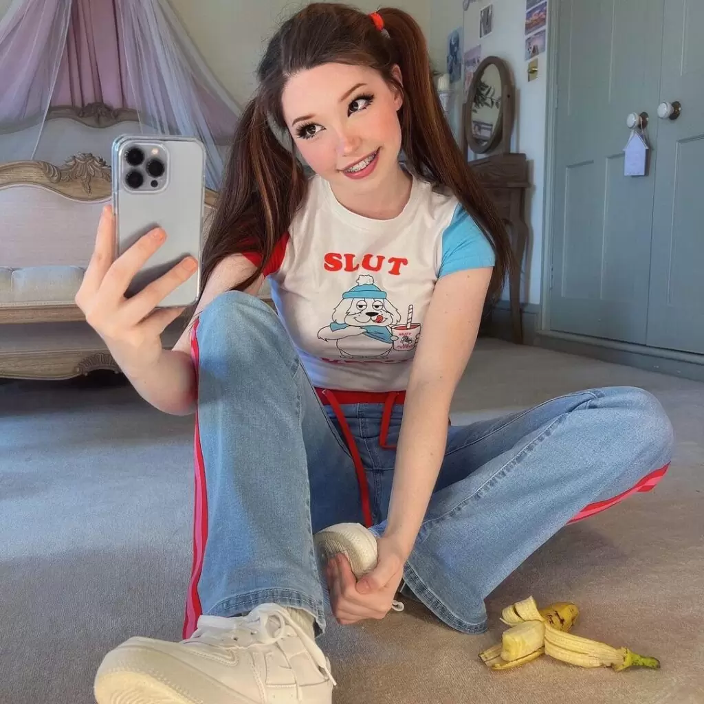 Belle Delphine is wearing white t shirt over trouser and standing in front of mirror while taking selfie