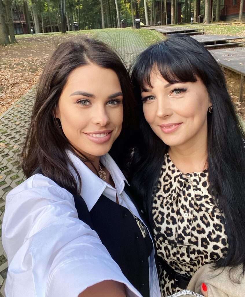 Iryna Pinchuk is standing with her mom and wearing white and black dress or taking the selfie