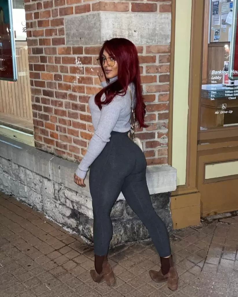 Lady Tarzán lleva una camisa elegante con jeans y gafas o posa para tomar la fotografía.