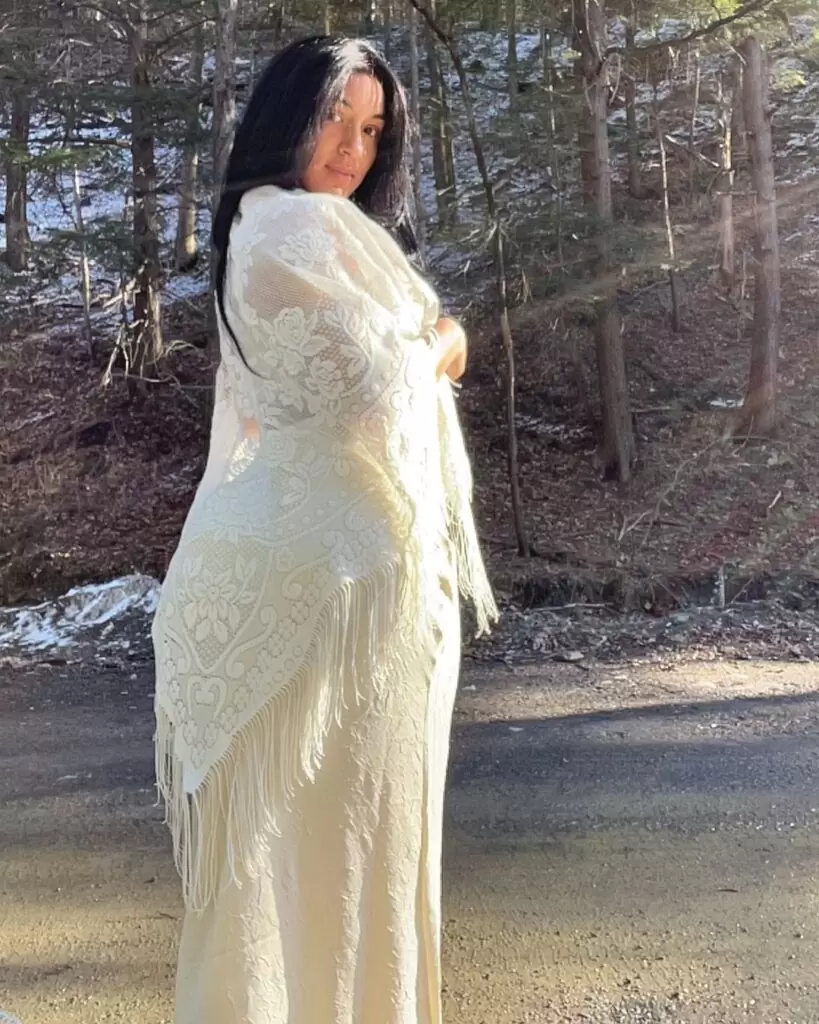 Lady Tarzán lleva un vestido blanco y posa mientras toma la fotografía.