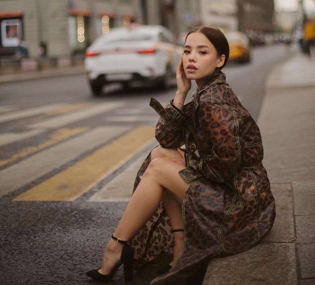 Lyna Com is wearing light black stylish dress or sitting while posing for the picture