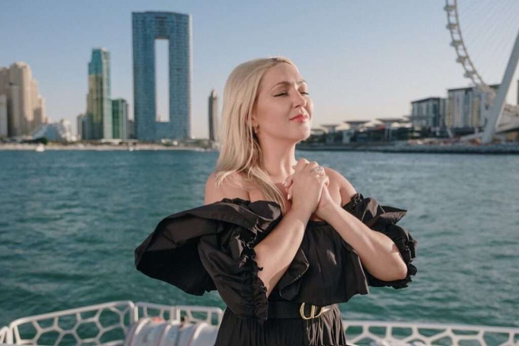 Mila Semeshkina is wearing black dress or standing on the sea side while posing for the picture