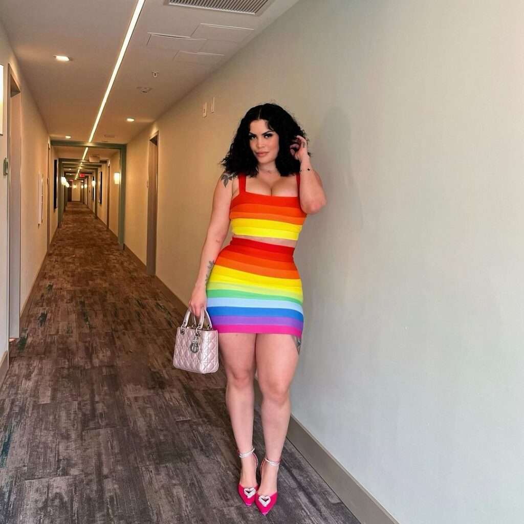 Sheyla Fong is wearing stylish colorful dress and holding the purse or posing for the picture