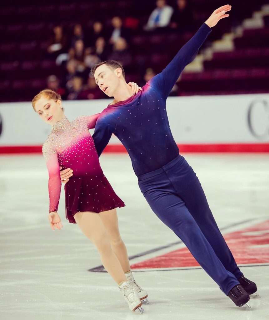 Bryce Chudak in the blue skating costume while performing with her wife, a random click