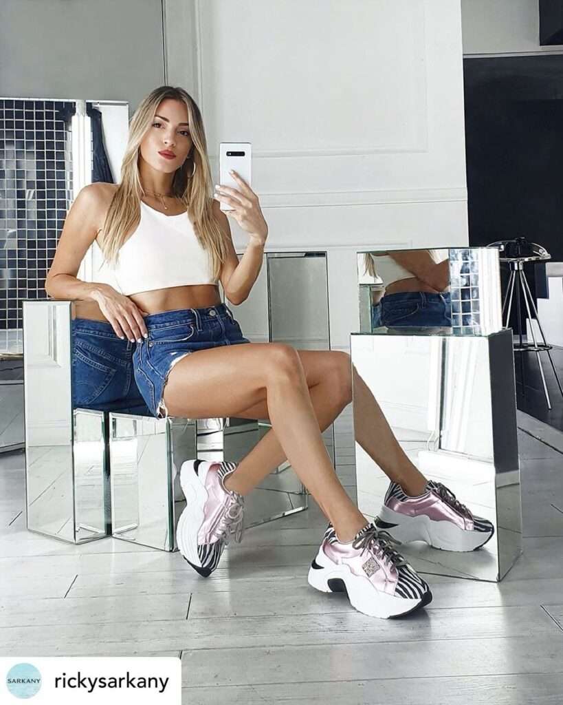 Christina Invernizzi is taking her mirror selfie as she is posing for a picture while wearing a bra with shorts.