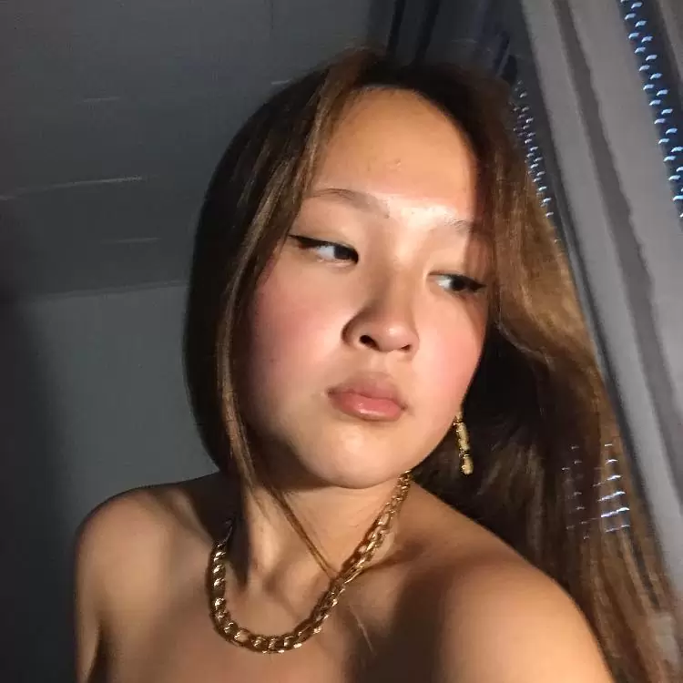 Kimmy Yang wearing a gold chain and posing for a picture