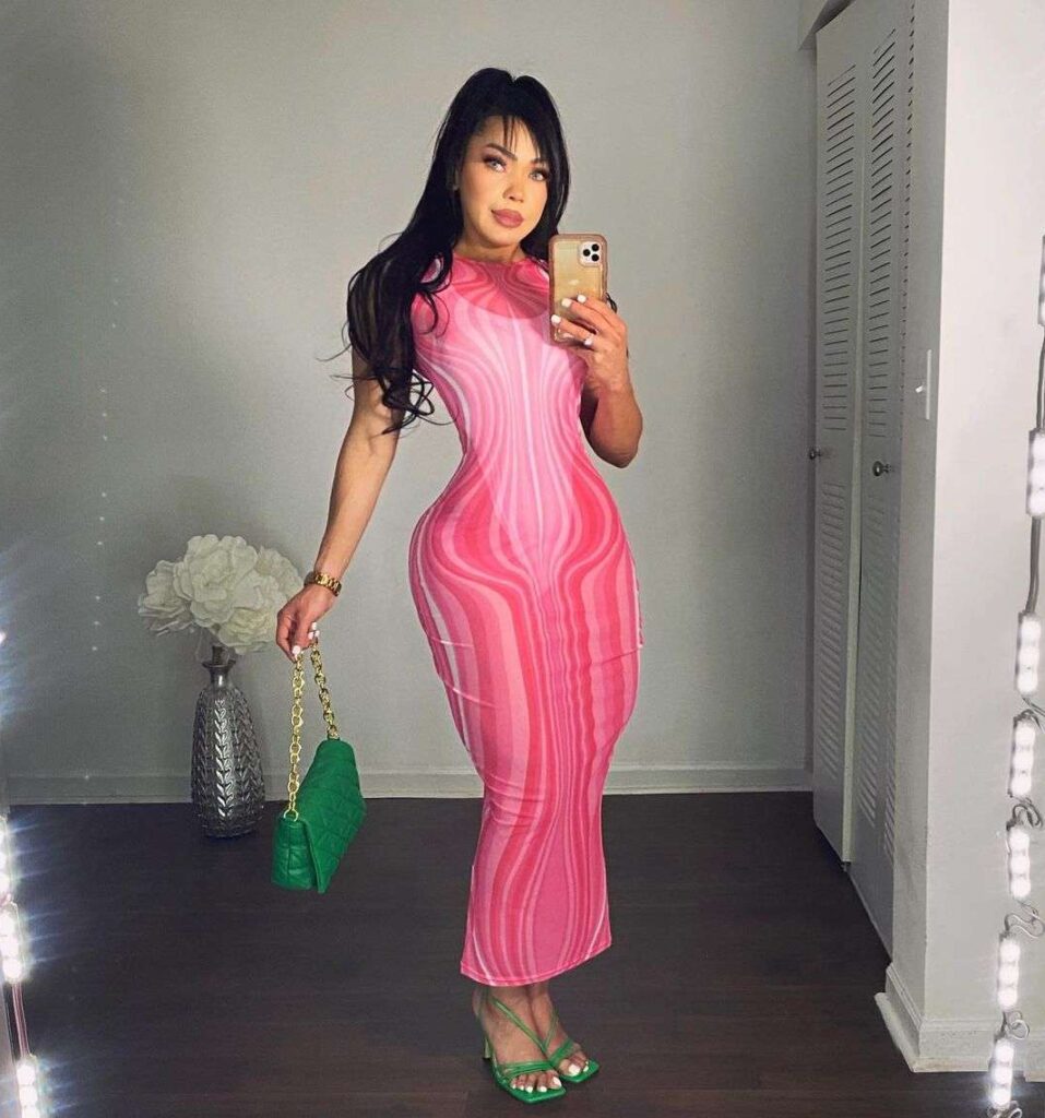 Marcia Andrades in the pink boydcon outfit pair with green heels while taking picture in the front of mirror