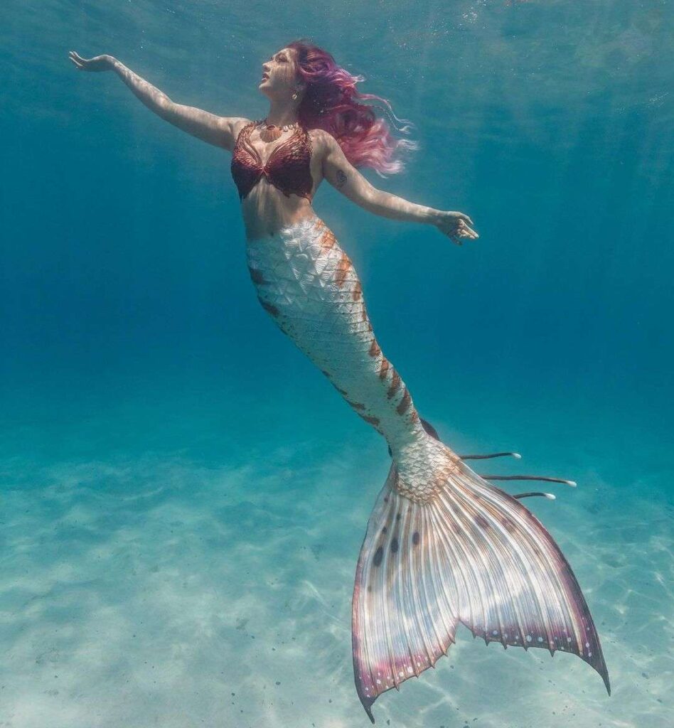 Mermaid Sirenity in the fish costume while swimming in the see