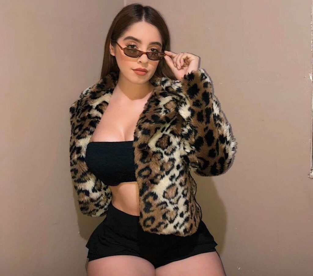 Michel Sánchez G in the black crop top pair with matching shorts and fur jacket while poses for a photo