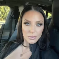 Angela White is wearing black dress and sitting in the car or posing while taking the picture