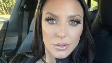 Angela White is wearing black dress and sitting in the car or posing while taking the picture