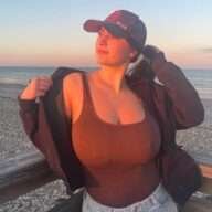Colleen Sheehan is wearing brown shirt over cap and taking sun kissed while posing for the picture