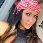 Olga Seteykina is wearing black ans sitting in the car or posing while taking the picture