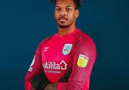 Jamal Blackman is wearing red shirt and gloves or posing while taking the picture