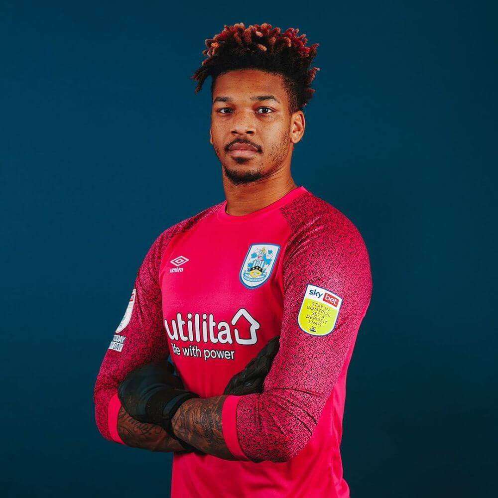 Jamal Blackman is wearing red shirt and gloves or posing while taking the picture